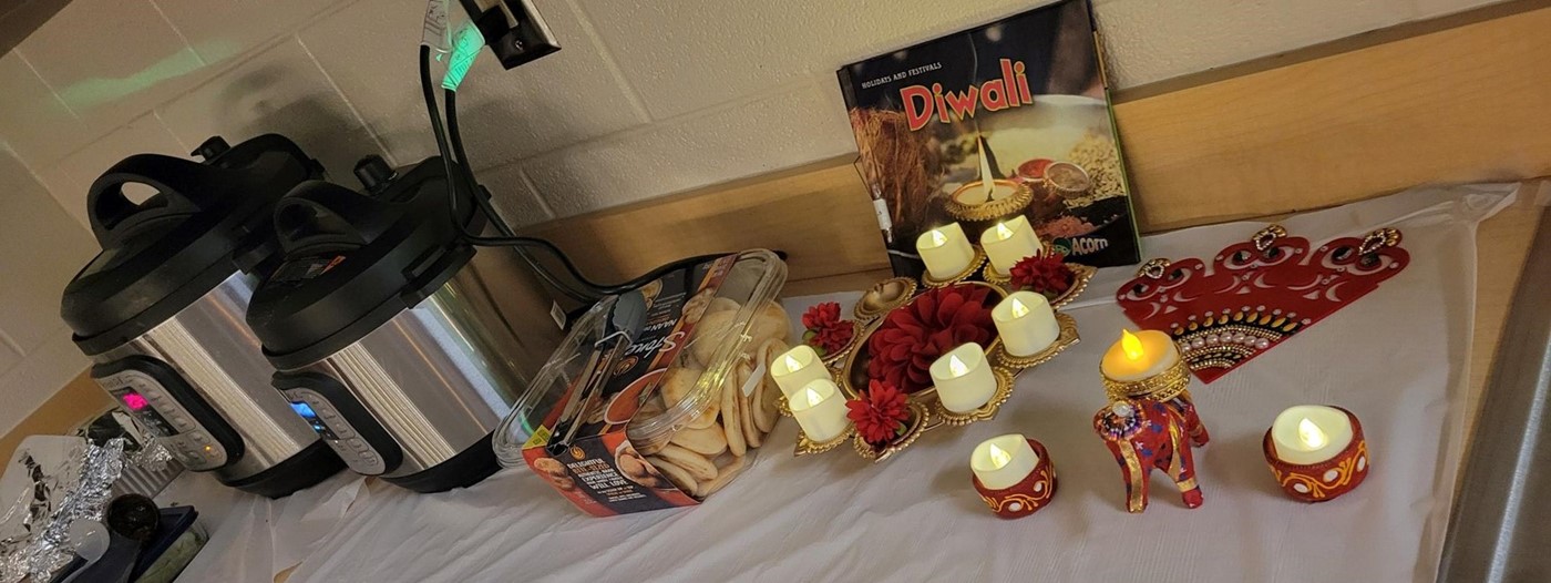 candles, food, Diwali book, and crockpots on a table