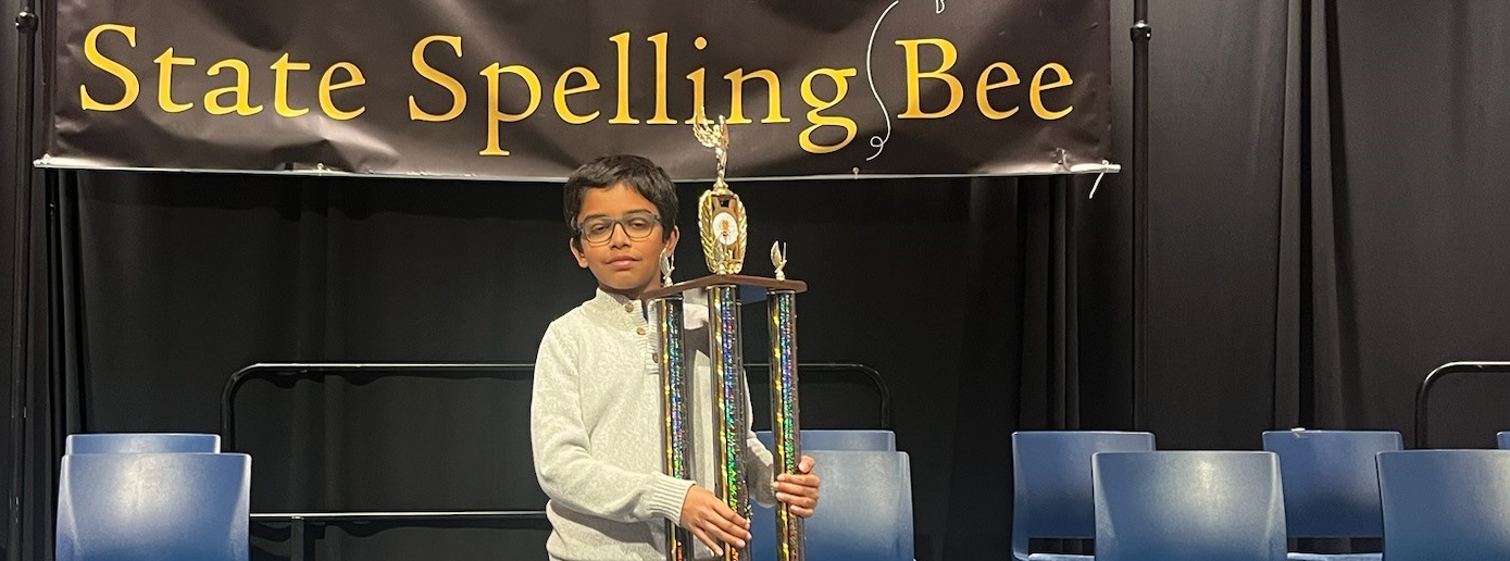 Sarv holding a trophy for winning the state spelling bee