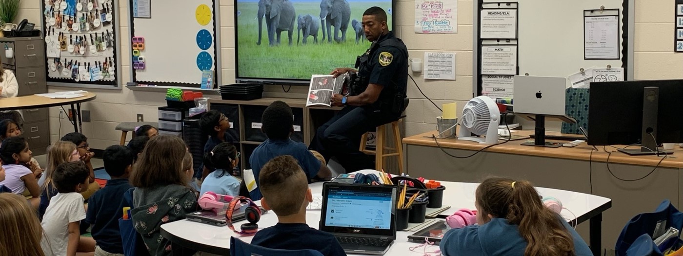 Police officer reading to 2nd graders