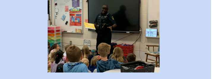 Dunwoody officer reading a book to a 2nd grade class