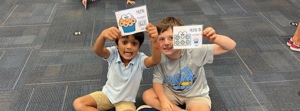 2 boys showing cards with a muffin and rectangle with 6 dots