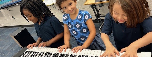 3 kids playing the keyboard