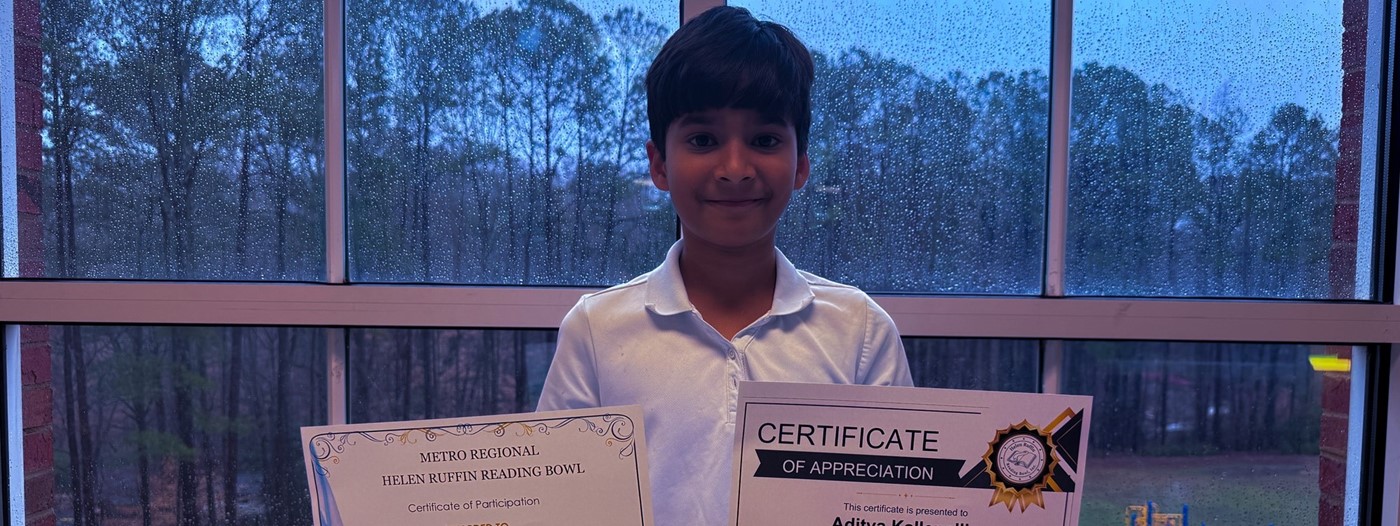 boy holding 2 certificates